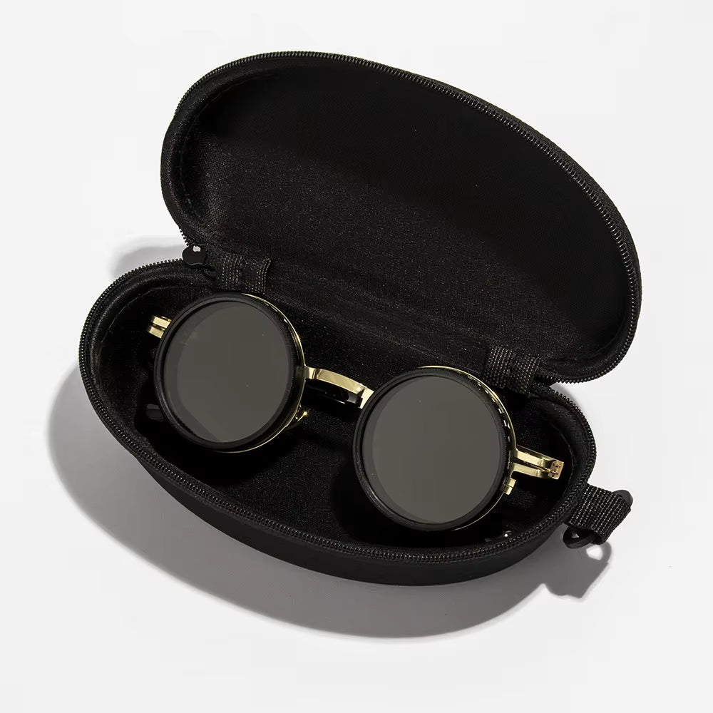 Black sunglasses with gold frames in an open black case on a white background