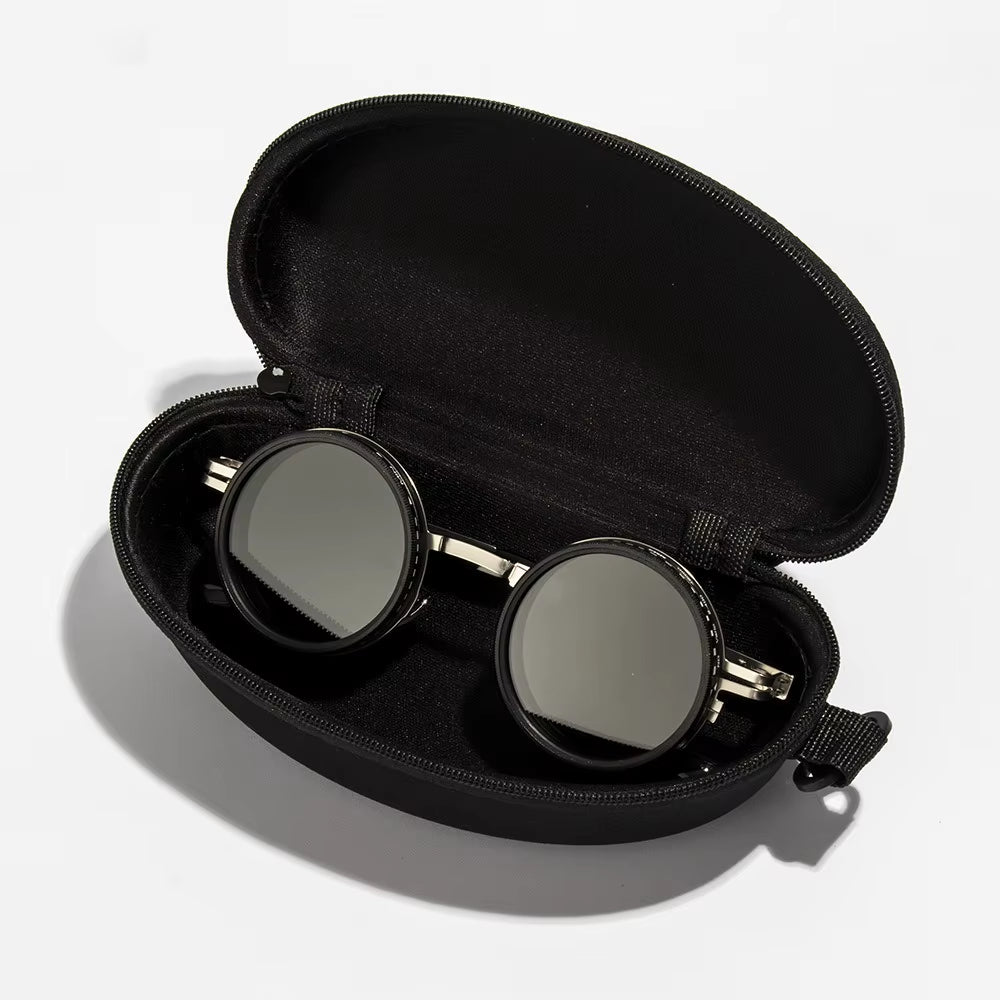 Round sunglasses with gold frames in a black case on a light gray background